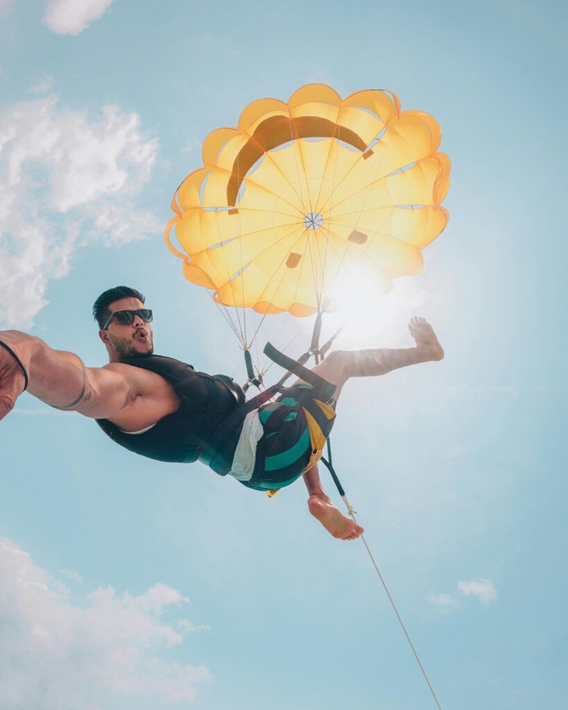 Exciting parasailing experience over Brazilian beach with vibrant yellow parachute and clear sky.