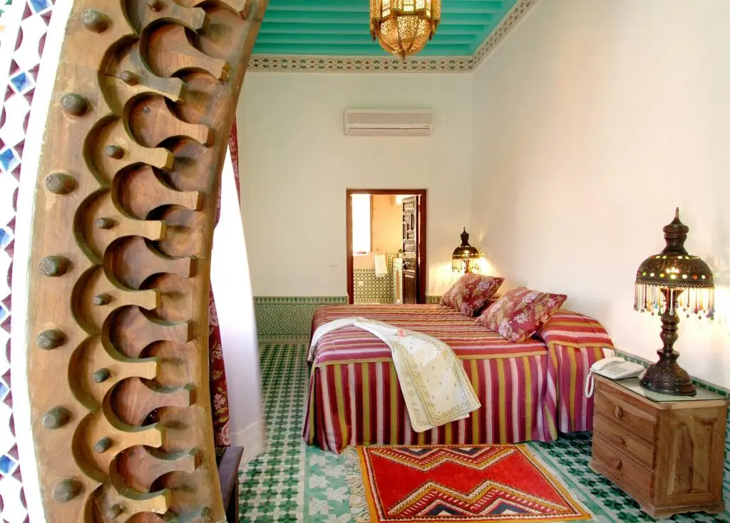 Beautiful Moroccan bedroom interior in Marrakech with traditional decor and colorful textiles.