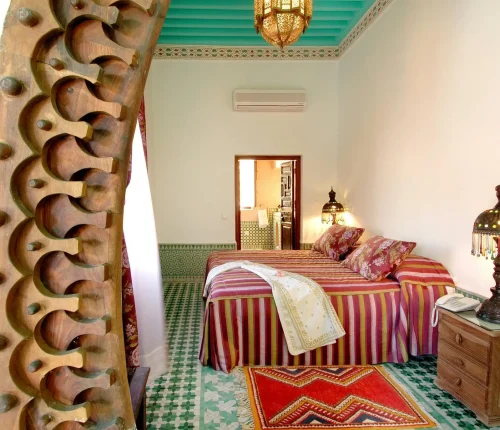 Beautiful Moroccan bedroom interior in Marrakech with traditional decor and colorful textiles.