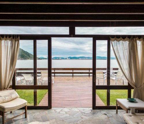 Elegant room with ocean view from large windows overlooking the beach in Brasil.