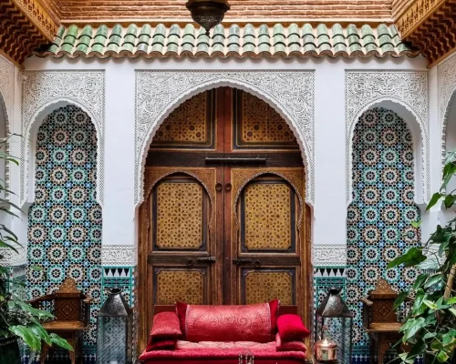 Stunning Moroccan riad courtyard with intricate tilework and central fountain.