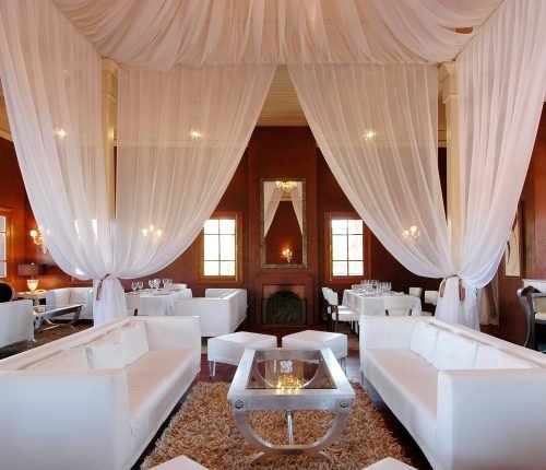 Elegant restaurant interior in Marrakech featuring luxurious draped ceilings and sophisticated furnishings.